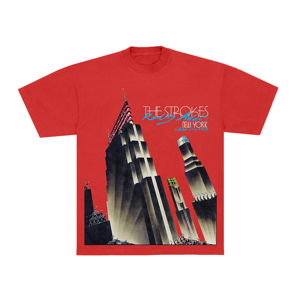 A red short-sleeve graphic t-shirt featuring a stylized art deco illustration of the New York City skyline, with 'THE STROKES' and 'NEW YORK' printed across the chest.