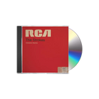 The album artwork for The Strokes' Comedown Machine CD is displayed flat against a plain, The cover mimics a vintage RCA magnetic tape box, featuring a bold, textured red background with a prominent yellow stripe down the left side and a classic, cream-colored RCA manufacturer label across the top. The album title is stamped in a minimalist, black sans-serif font across the center, giving the packaging a retro, analog media aesthetic.