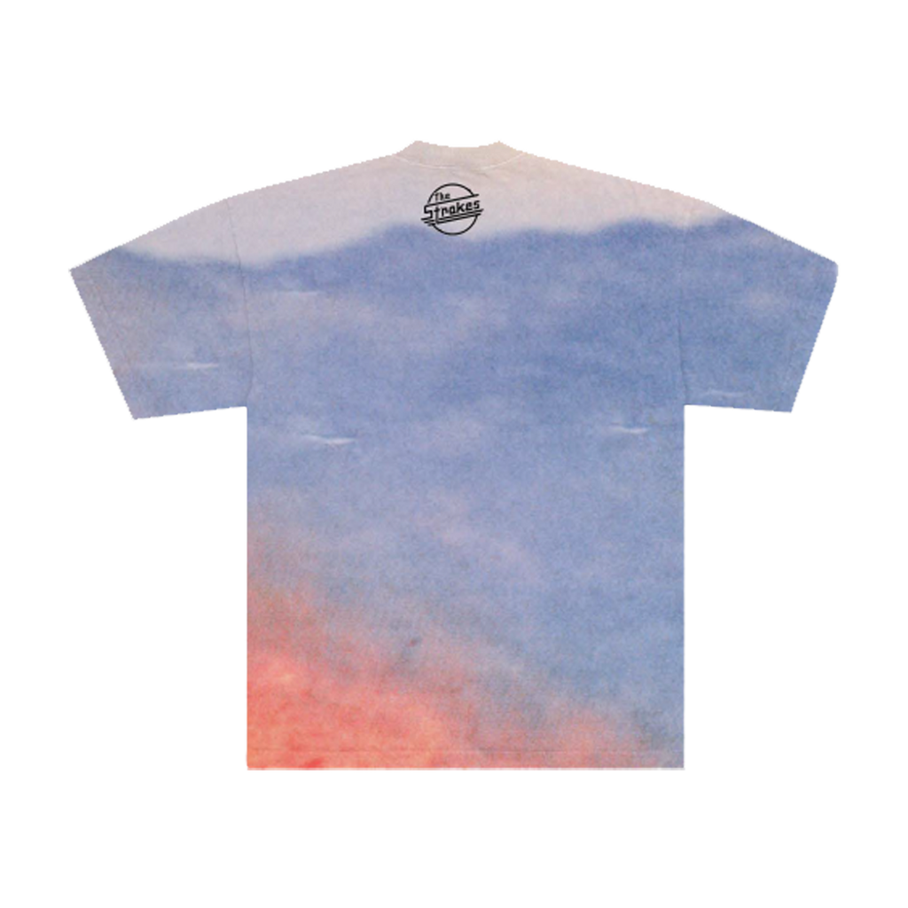 Back of a T-shirt with a mountain range background and a black "The Strokes". symbol underneath the neck collar. 
