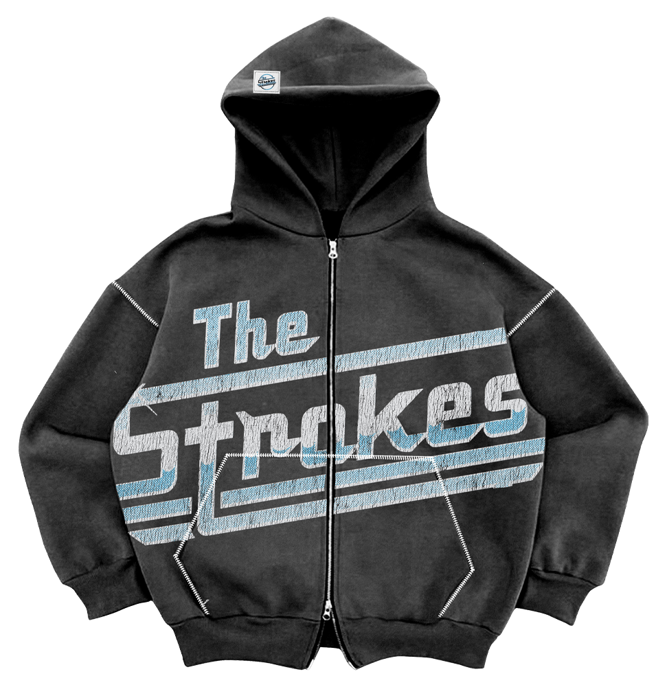 An oversized grey/black hoodie with double zipper, pockets, and a drawstring-free hood, featuring 'The Strokes' text and logo in blue and white across the front body
