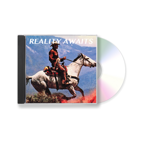 The Strokes Reality Awaits CD Case  with a cowboy on a horse in front of a mountainous background. The CD is poking out of the CD Case.