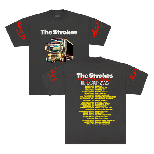 Front and back views of a dark charcoal gray short-sleeve t-shirt for the band The Strokes. The front features the THE STROKES logo in white text above a colorful graphic of a dekotora truck with red script text on both sleeves and 2026 tour dates down the back in yellow.