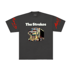 Dark grey t-shirt for the band The Strokes. The front features THE STROKES logo in white text above a colorful graphic of a dekotora truck with red script text on both sleeves.