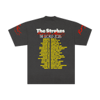 Dark grey t-shirt for the band The Strokes. Back of t-shirt features The Strokes Reality Awaits The World 2026 across the top with the 2026 tour itinerary in yellow down the back.