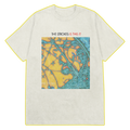 A beige colored t-shirt featuring a print of The Strokes Is This It album cover that features a colorful, abstract design with blue and orange predominating, and the band's name at the bottom left in white with with "THE STROKES IS THIS IT" text above the album art. 