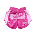 A pair of pink Muay Thai shorts with lighter pink graphics, including a logo on a notes sheet and musical notes.