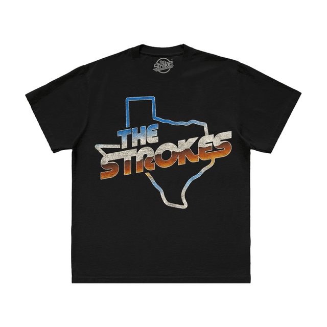 The Strokes logo against the outline of the great state of Texas all in shades of blue, vintage white, and rust brown, printed on the front of a unisex black t-shirt.