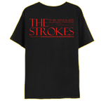 The back of a black shirt with "THE STROKES" in red prominently with The SINGLES, 06.25.2001-09.06.2006 and Volume 1" surrounding in smaller text 